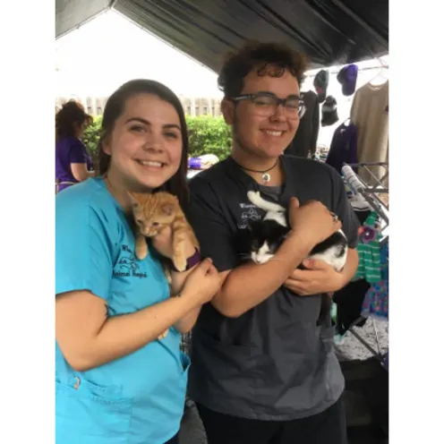 Two Staff Members Holding Cats